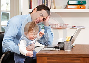 Stressed Man With Baby Working From Home photo