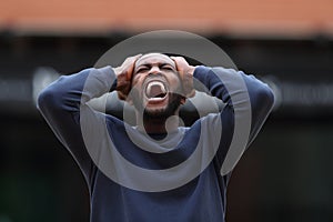 Stressed man with black skin yelling in the street