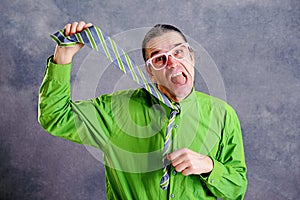 Stressed man in green shirt pink glasses strangle with necktie