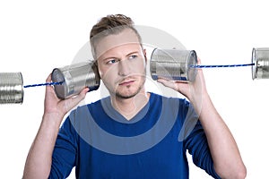 Stressed man overworked holding tin can phones isolated on white
