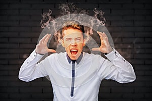 Stressed man screaming with smoke coming out of his ears