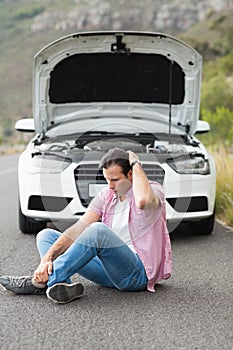 Stressed man sitting after a car breakdown