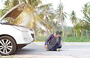 Stressed man sitting after a car breakdown