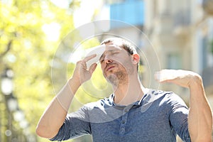 Stressed man sweating suffering heat stroke a warm day photo