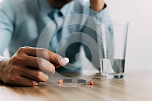 Stressed man taking pills from drugs relieve symptoms