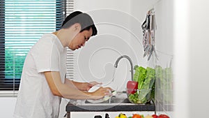 Stressed man washing vegetables in the sink in the kitchen at home