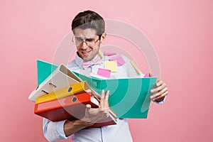Stressed mid aged man employee holding stack