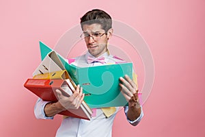 Stressed mid aged man employee holding stack
