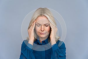 Stressed middle aged lady suffering from headache or migraine, close up view.