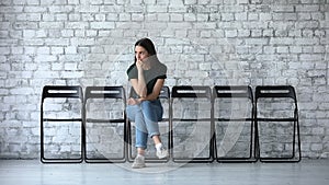 Stressed millennial businesswoman wait for job interview sit on chair