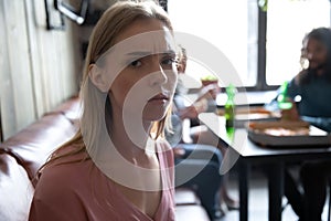 Stressed millennial girl outcast sit alone in cafe