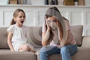 Stressed mother feeling desperate about screaming stubborn kid daughter tantrum