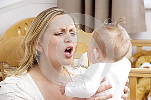 Stressed Mother Holding Baby In Nursery