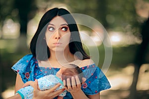 Stressed Mother Holding Newborn Baby in Her Arms