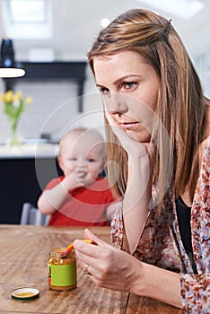 Stressed Mother Trying To Feed Fussy Baby