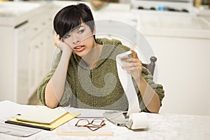 Stressed Multi-ethnic Young Woman Agonizing Over Financial Calculations photo