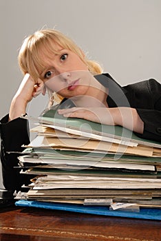 Stressed office executive with stack of paperwork