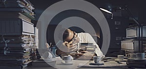 Stressed office worker sleeping at his desk