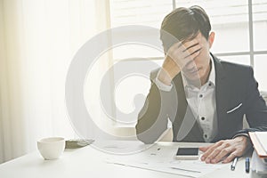 A stressed out business man holds his head in despair