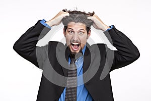 Stressed out businessman pulling his hair and screaming