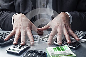 Stressed out financial manager with a bunch of calculators