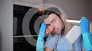 Stressed out man cleaning his kitchen