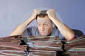 Stressed out man at work pulling his hair out.