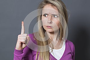 Stressed out young woman raising her finger for frustrating signal