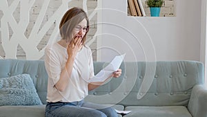 Stressed over bills. Unpset woman looking at her financial debts at home.