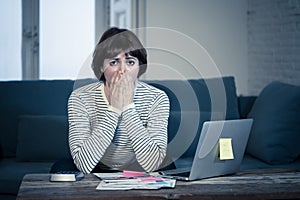 Stressed and overwhelmed young woman trying to manage home finances paying bills feeling desperate