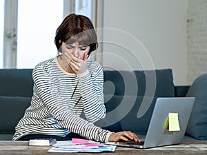 Stressed and overwhelmed young woman trying to manage home finances paying bills feeling desperate