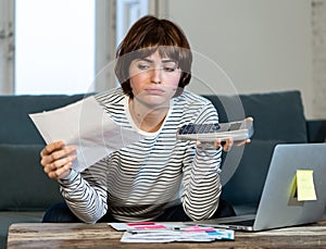 Stressed and overwhelmed young woman trying to manage home finances paying bills feeling desperate