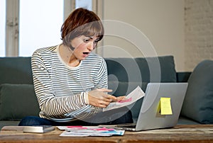 Stressed and overwhelmed young woman trying to manage home finances paying bills feeling desperate