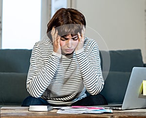 Stressed and overwhelmed young woman trying to manage home finances paying bills feeling desperate