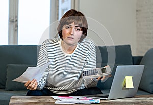 Stressed and overwhelmed young woman trying to manage home finances paying bills feeling desperate