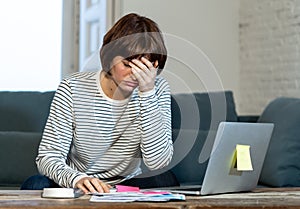 Stressed and overwhelmed young woman trying to manage home finances paying bills feeling desperate