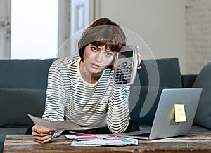 Stressed and overwhelmed young woman trying to manage home finances paying bills feeling desperate