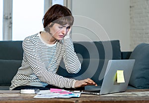 Stressed and overwhelmed young woman trying to manage home finances paying bills feeling desperate