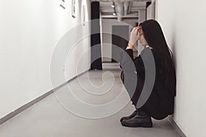 Stressed overworked young business woman sitting on floor. Fired and depressed in office.
