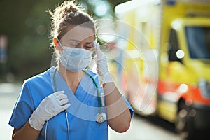 Stressed paramedic woman with stethoscope and medical mask