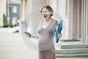 Stressed pregnant woman screaming on the street