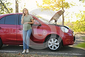 Stressed pregnant woman talking on phone near broken car outdoors