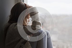 Stressed Sad Teen sitting alone and looking out the window