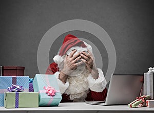 Stressed Santa connecting with his laptop