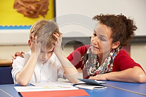 Stressed Schoolboy Studying In Classroom photo