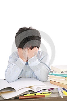 Stressed schoolboy studying in classroom