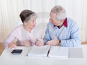 Stressed senior couple calculating budget