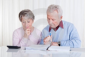 Stressed senior couple calculating budget