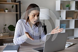 Stressed shocked computer user staring at laptop screen