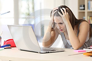 Stressed student memorizing on laptop studying at home